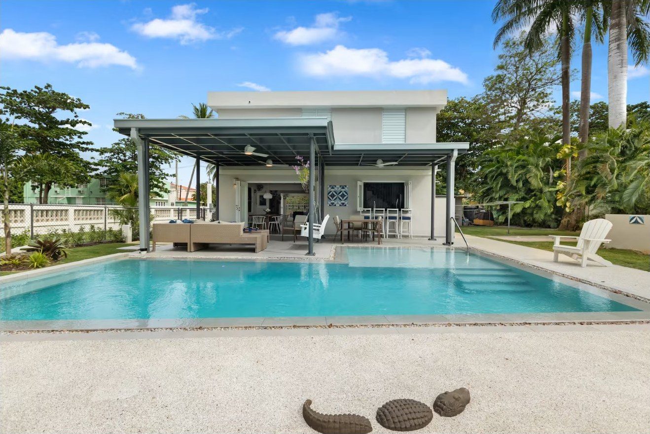 Pool with the open-air living and dining patio behind